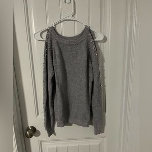 Gray shoulder hole sweater with pearl beading along the sleeves.